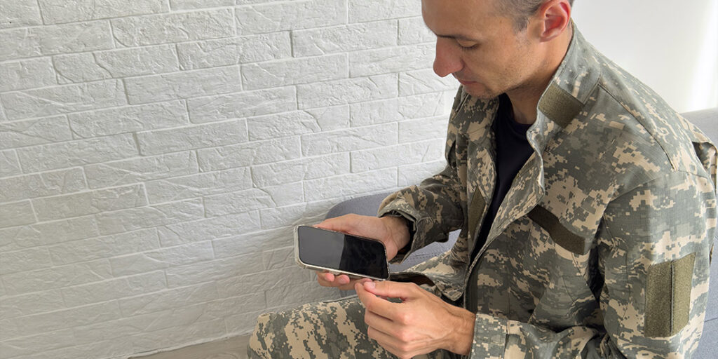 Militare con in mano uno smartphone